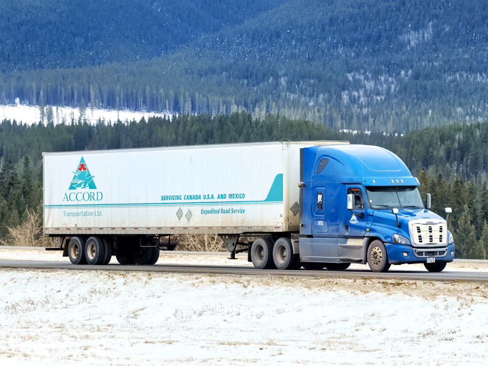 Camion d’Accord Transportation sur une route de montagne enneigée
