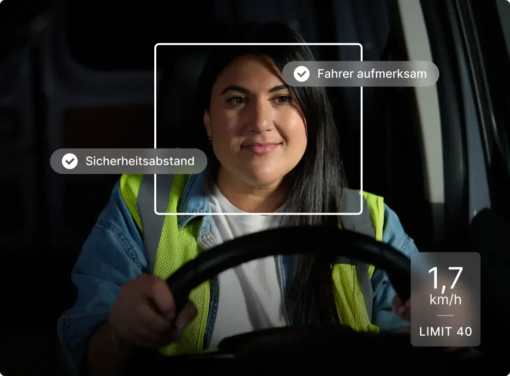 Driver in safety vest behind wheel with monitoring interface showing "Driver Attentive" and speed limit indicators.