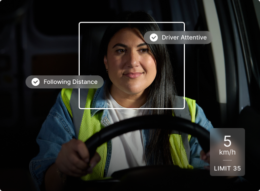 Driver in safety vest behind wheel with monitoring interface showing "Driver Attentive" and speed limit indicators.