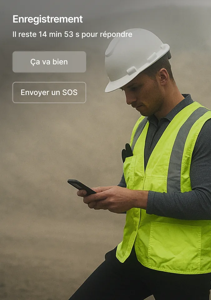 Un travailleur de la construction avec un casque blanc consultant l’interface de suivi de sécurité sur son téléphone.