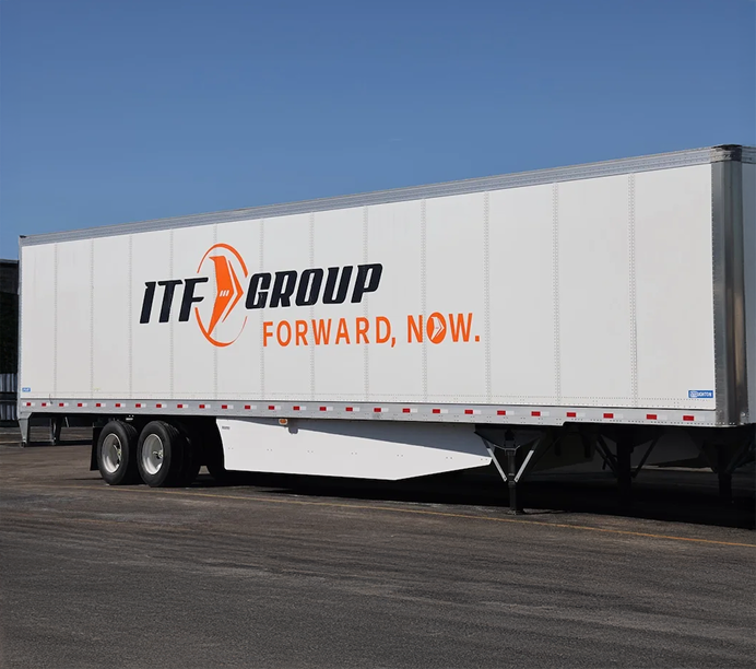 White semi-truck trailer with ITF GROUP logo and "FORWARD, NOW." slogan in black and orange against a blue sky.