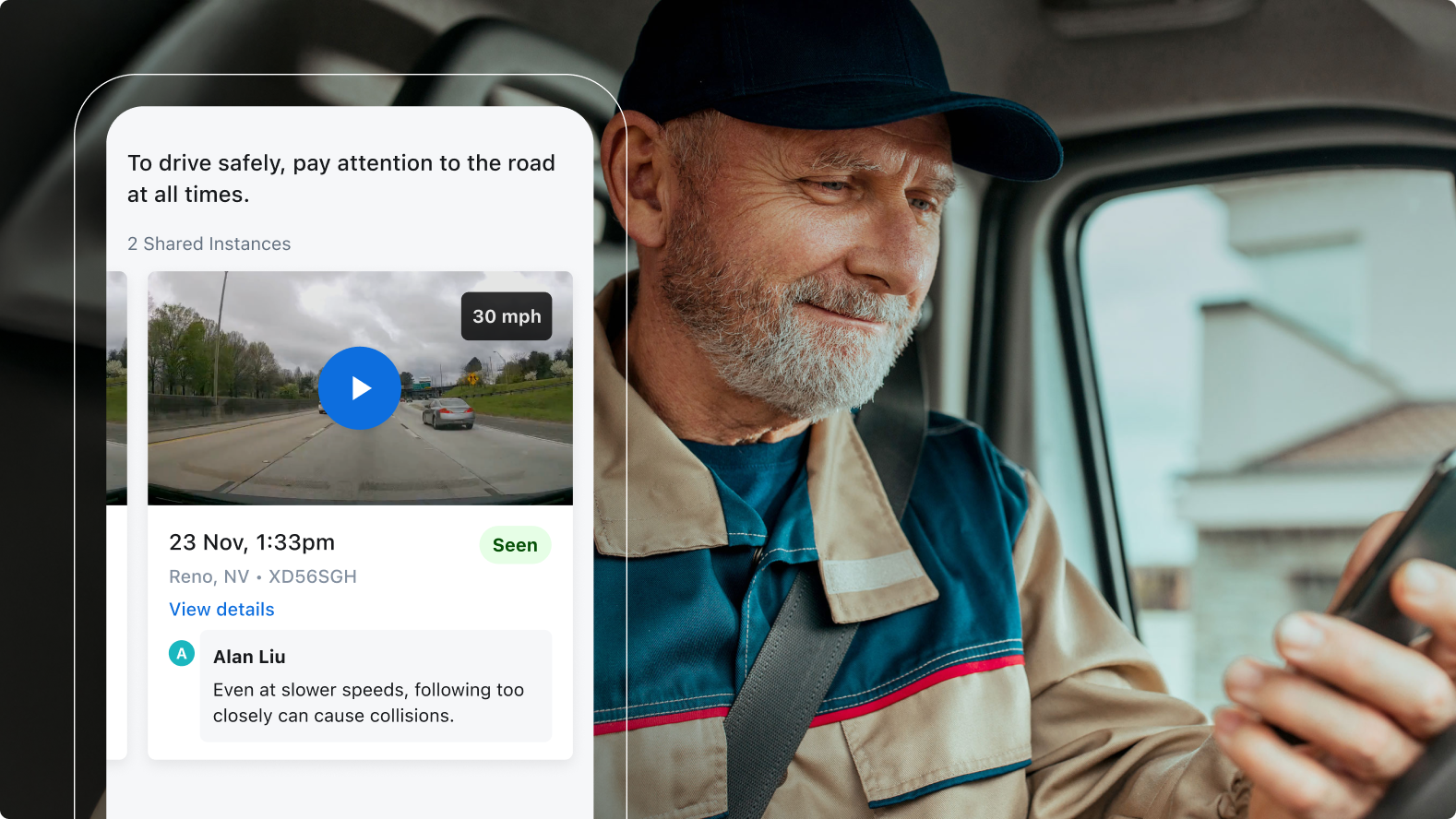 Driver in blue cap checking phone while a safety notification about paying attention to the road appears on screen.