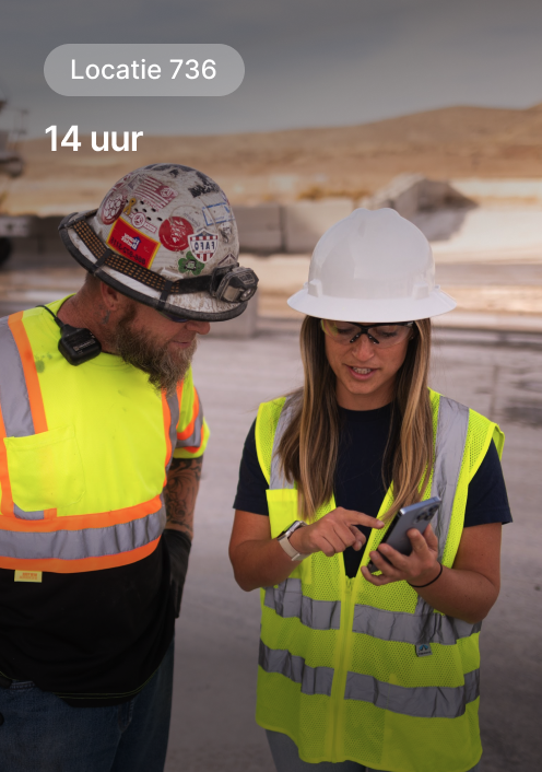 Twee bouwvakkers, veiligheidshesjes, helmen, op locatie nr. 736 tijdens een dienst van 14 uur in een woestijnomgeving.