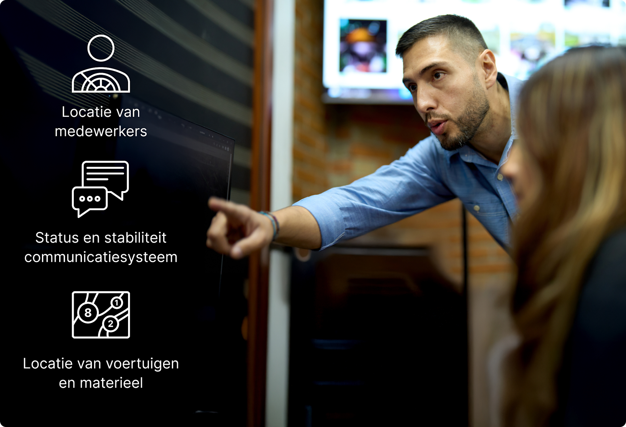 Iemand wijst naar een scherm met pictogrammen van het volgsysteem voor personeel, communicatiestatus en voertuiglocaties.