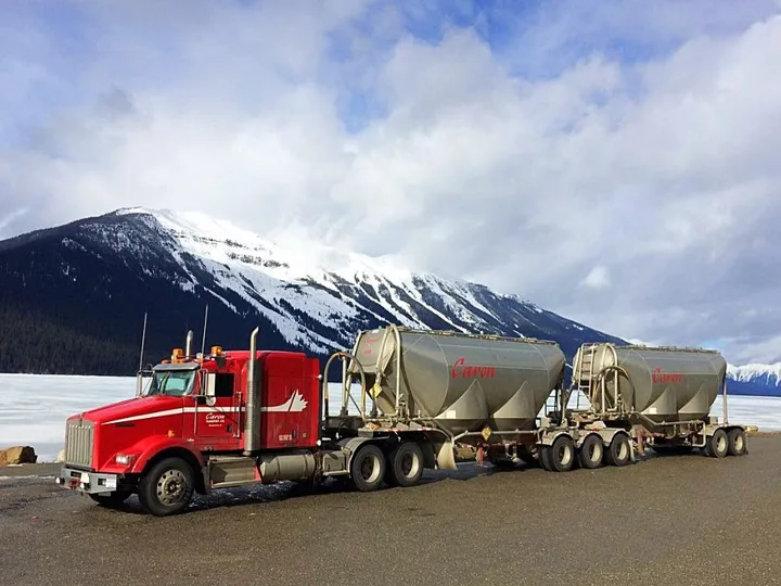 Camion de Caron Transportation avec vue sur les montagnes de l'Ouest canadien.