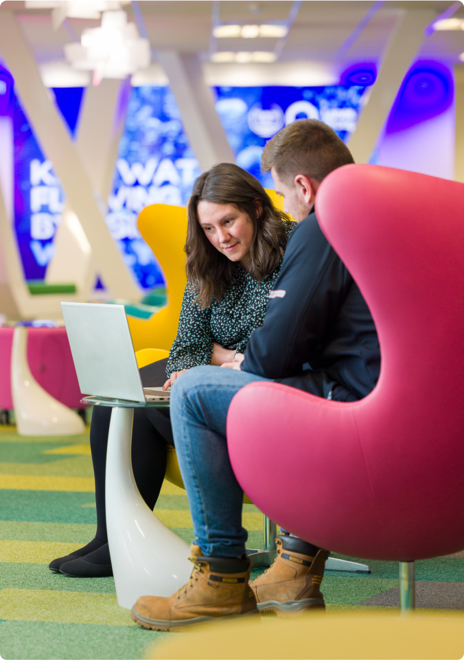 two people sitting looking at a laptop