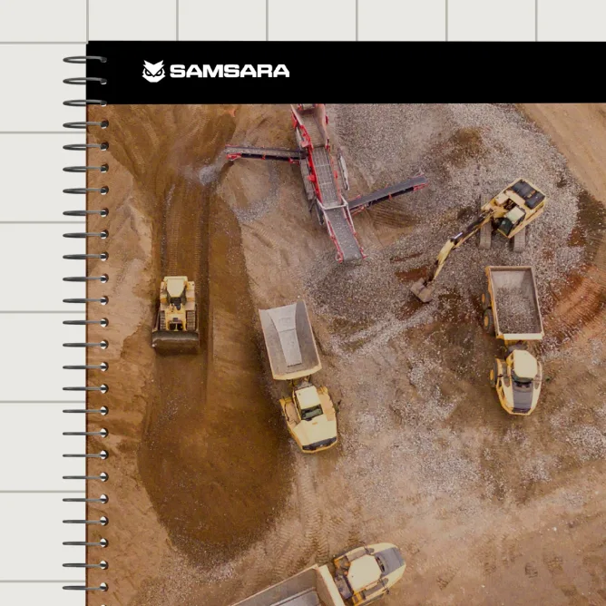 Aerial view of a construction site with yellow heavy machinery, dump trucks, and excavators moving dirt and gravel.