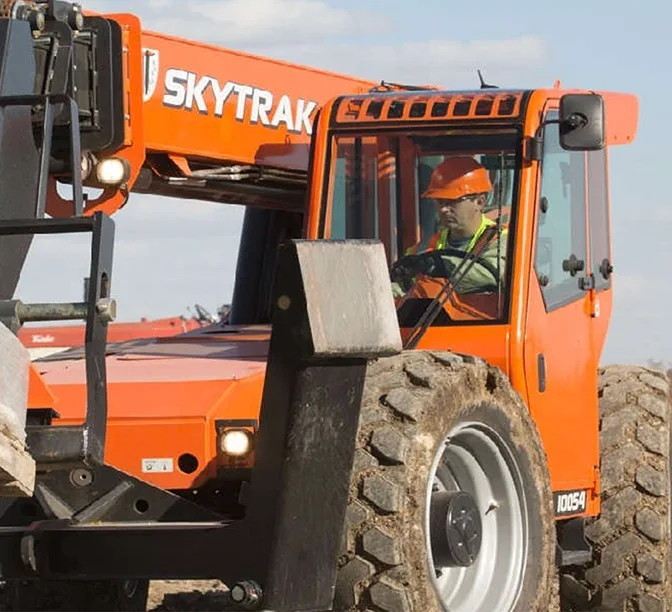Manipulador telescópico SKYTRAK con operador con equipo de seguridad, en el equipo de construcción en un sitio de trabajo.