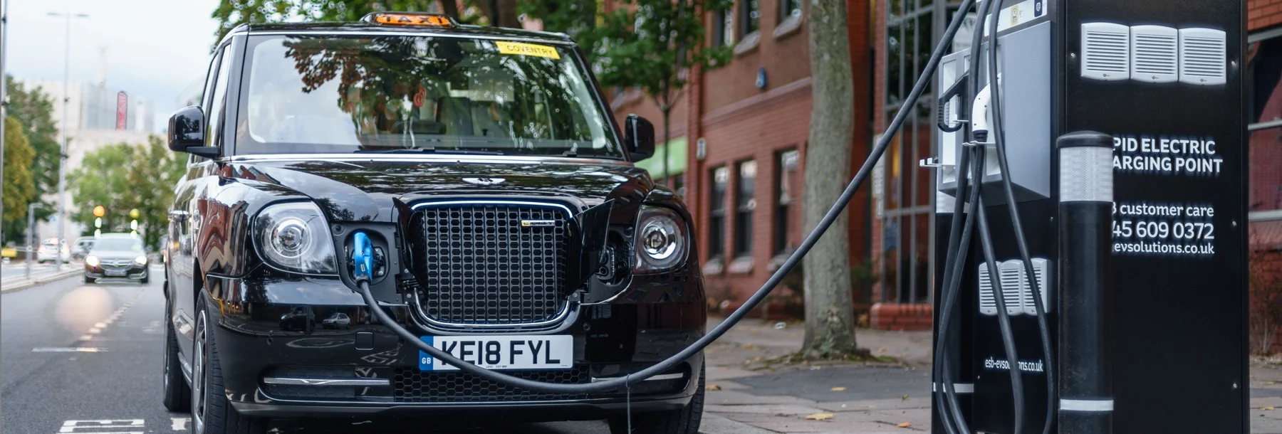 Black cab next to charging station in London