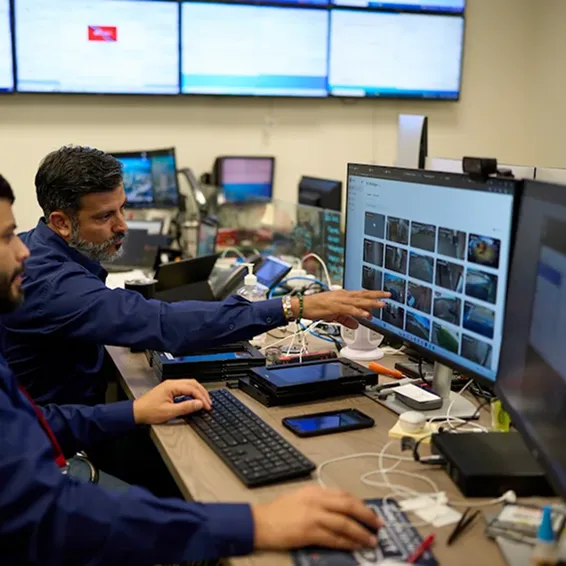 Two employees looking at monitor and discussing about the real-time information that Samsara provides to improve operations