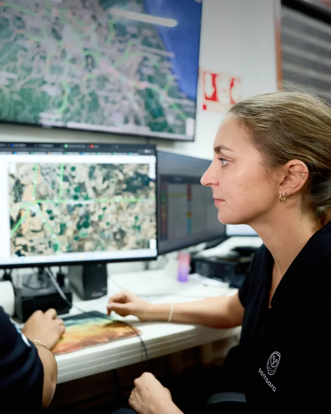 Personnes regardent moniteurs montrant cartes de l'emplacement de leur flotte via tableau de bord de la plateforme Samsara.