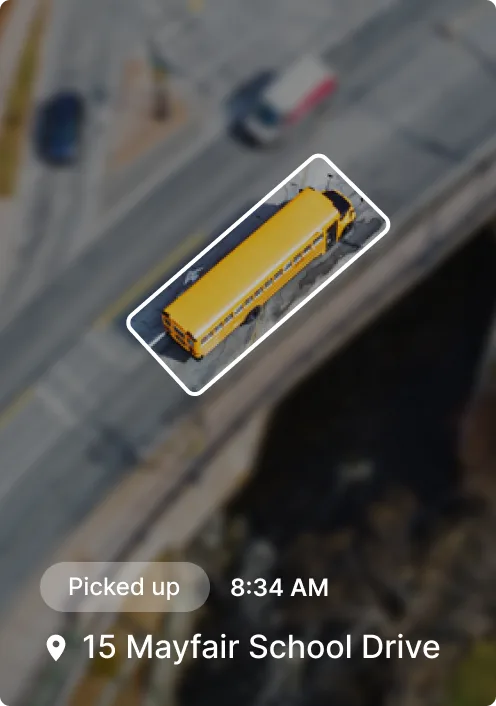 Aerial view of a yellow school bus highlighted on a road, showing pickup at 8:34 AM from 15 Mayfair School Drive.