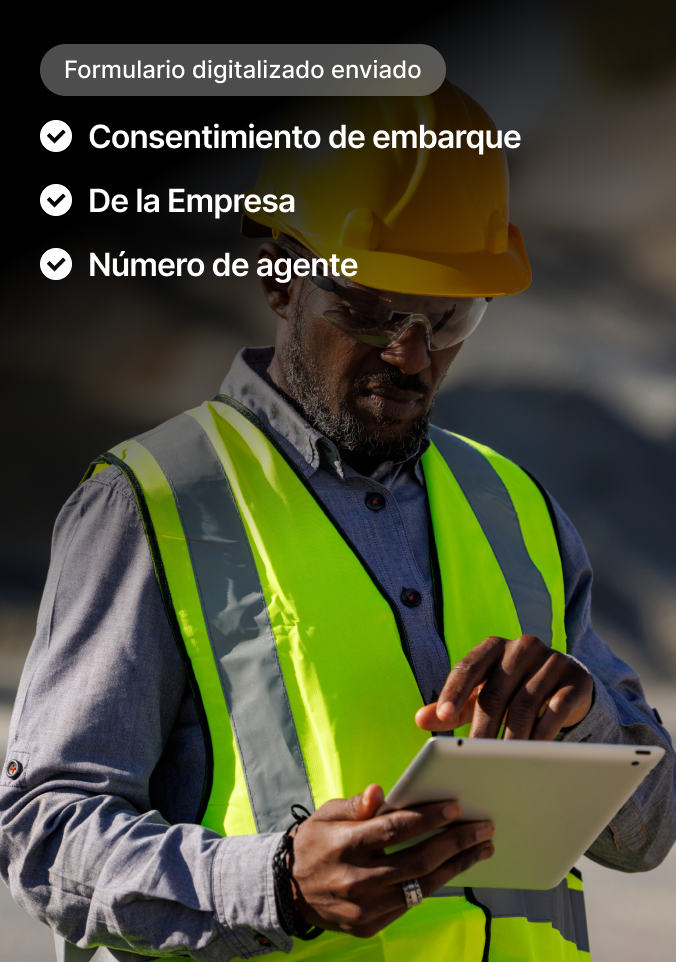 Albañil con casco amarillo y chaleco de seguridad usa tableta con interfaz visible para enviar formularios digitales.
