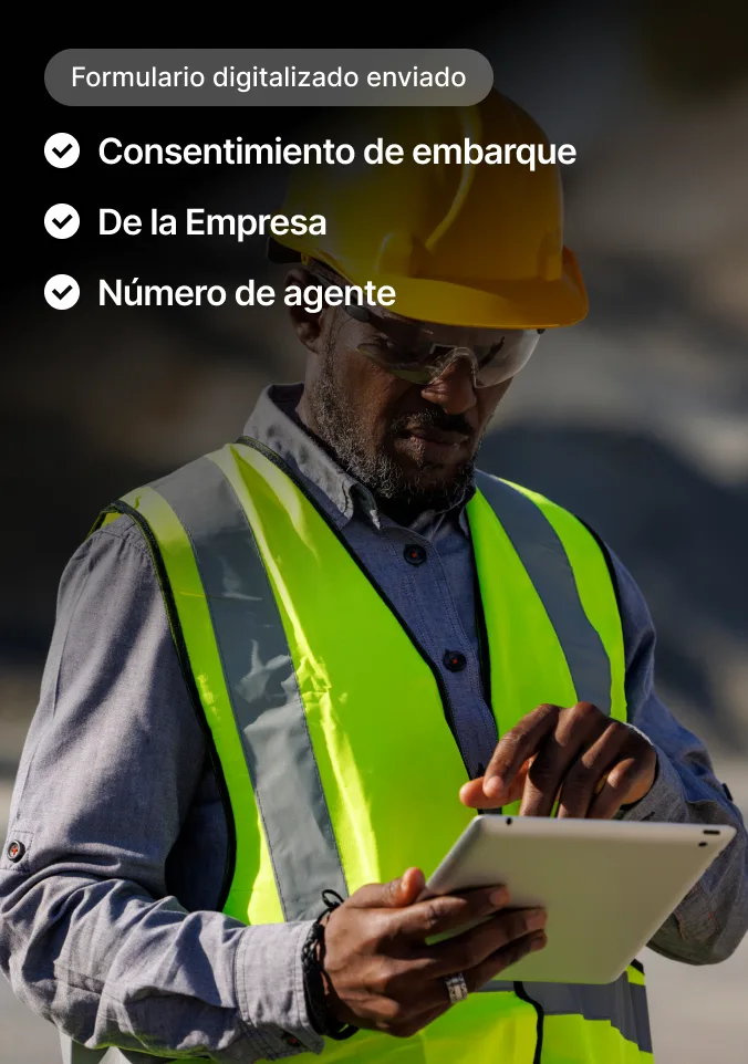 Albañil con casco amarillo y chaleco de seguridad usa tableta con interfaz visible para enviar formularios digitales.