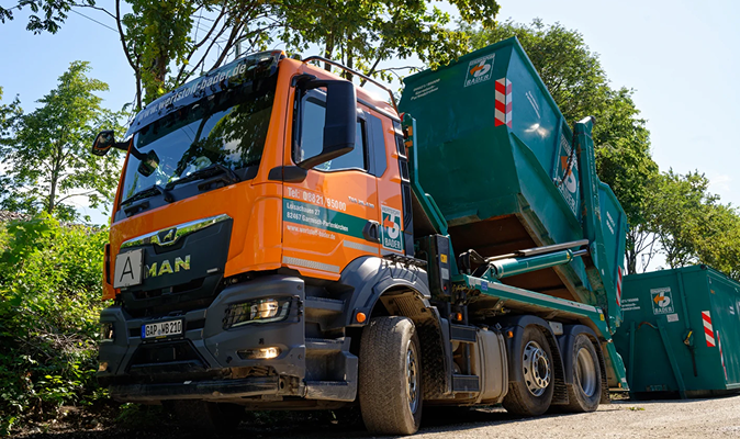 Auf einem geneigten Wohnhausdach installieren Arbeiter Solarmodule. Darunter ist ein geparkter Sunrun-Firmenwagen zu sehen.