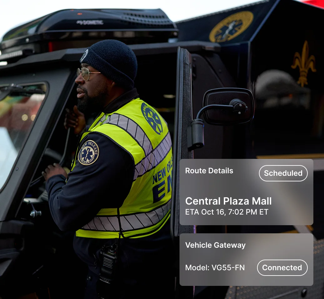 Emergency medical technician in high-visibility vest beside vehicle with route details showing destination.