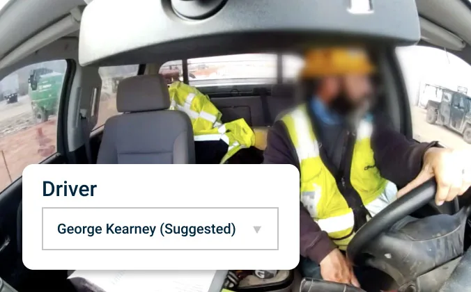 Driver with hands on the wheel, an overlay shows driver assignment name.