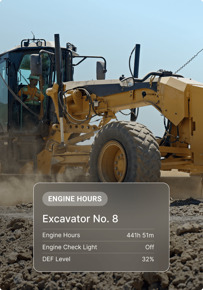 Yellow motor grader with operator in cab, showing equipment status display with engine hours and DEF level information.