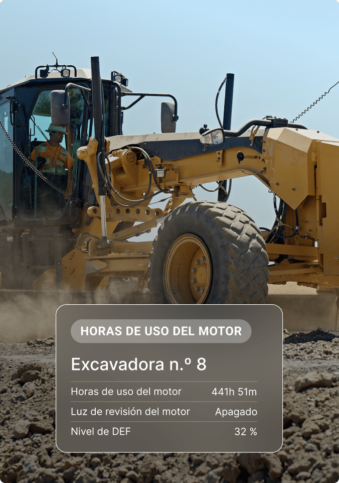 Motoniveladora amarilla con operador, pantalla de estado del equipo con información de horas de uso del motor y nivel de DEF.