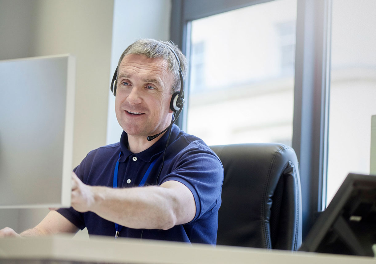 Delivery driver with headset receiving dispatch notification about route change, with message overlay showing communication.