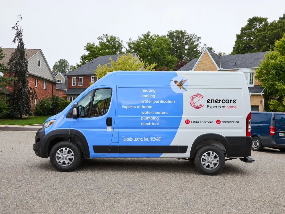 Blue and white Enercare van parked on a residential street