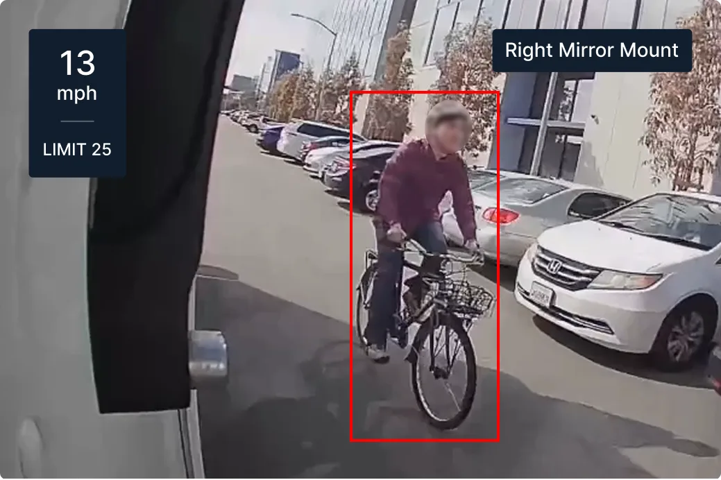 Dashboard view showing cyclist on street with parked cars, speed display showing 13 mph in 25 mph zone.