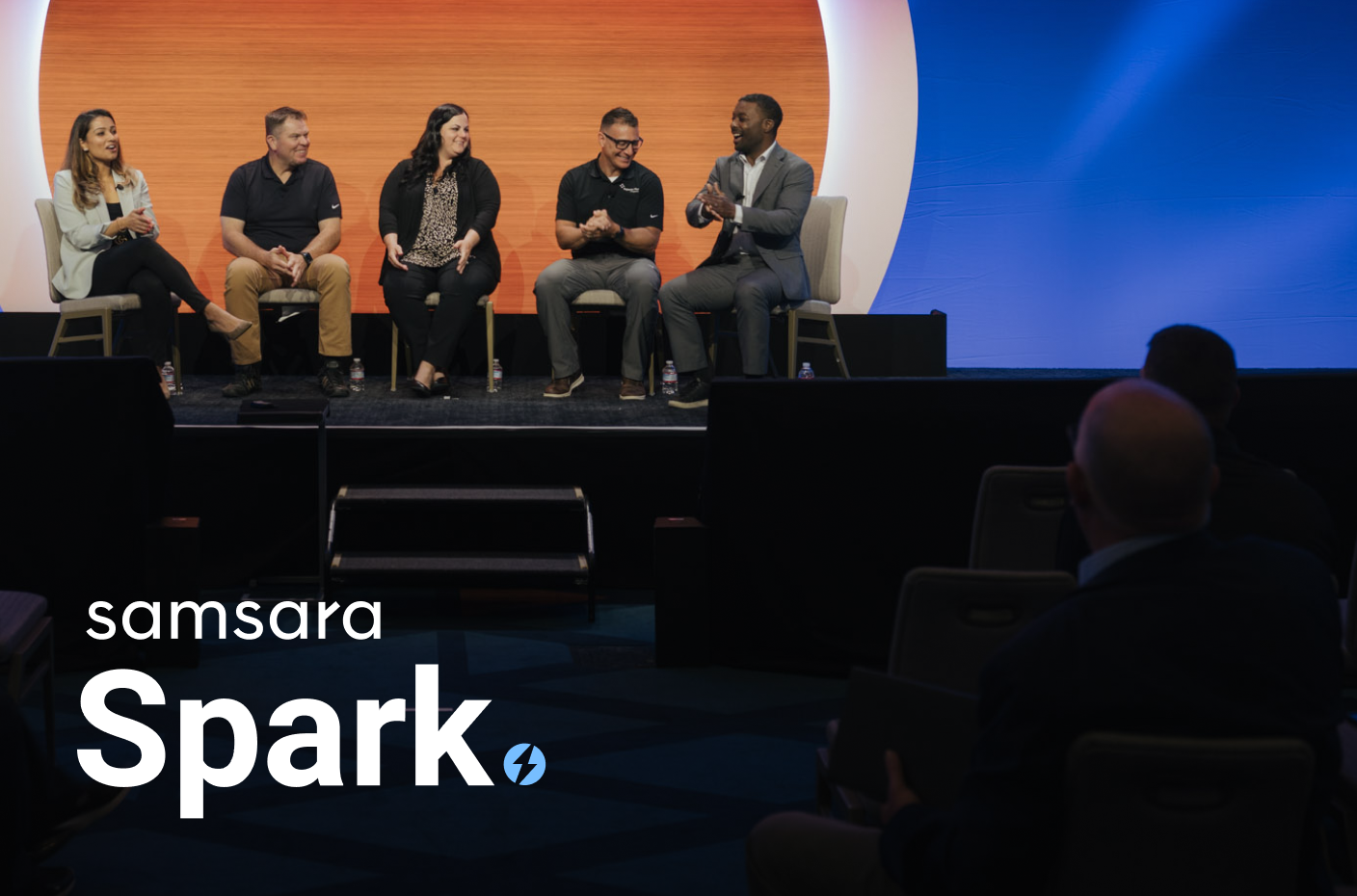 A group of people sitting on a stage for a panel discussion.