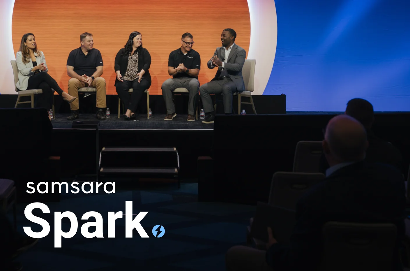 A group of people sitting on a stage for a panel discussion.