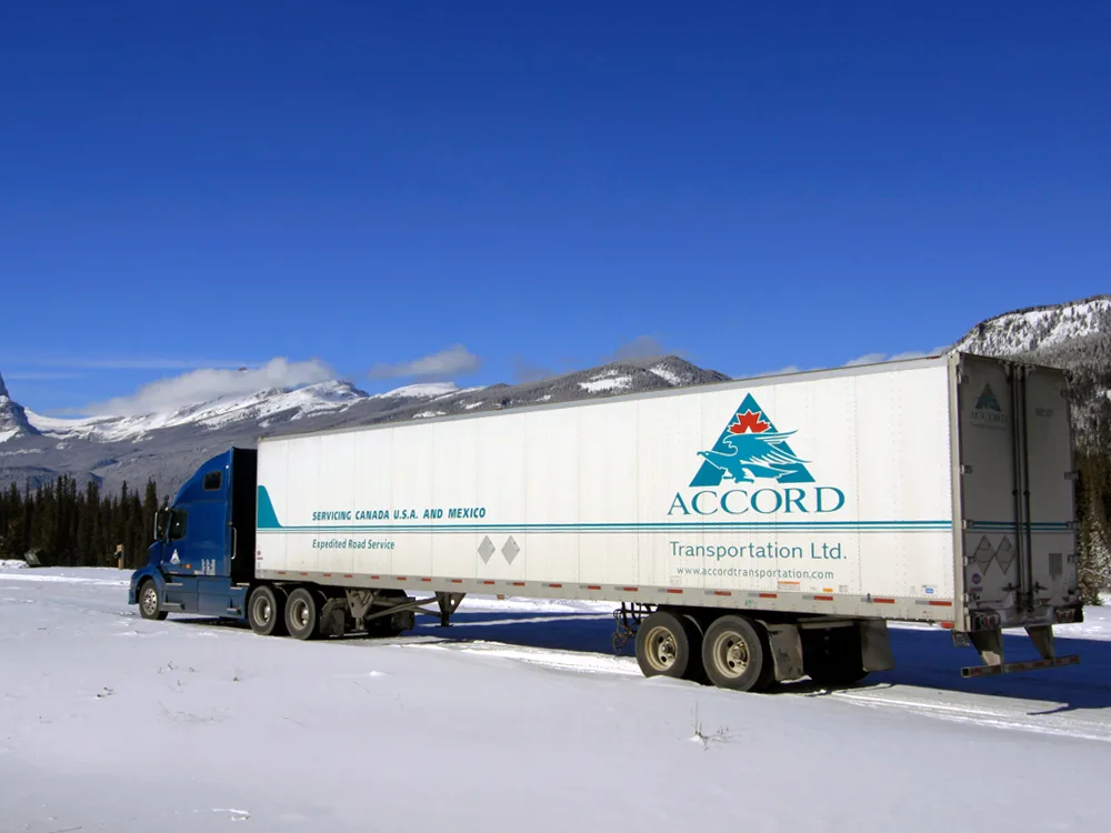 Accord Transportation truck on winter road with mountains in the background