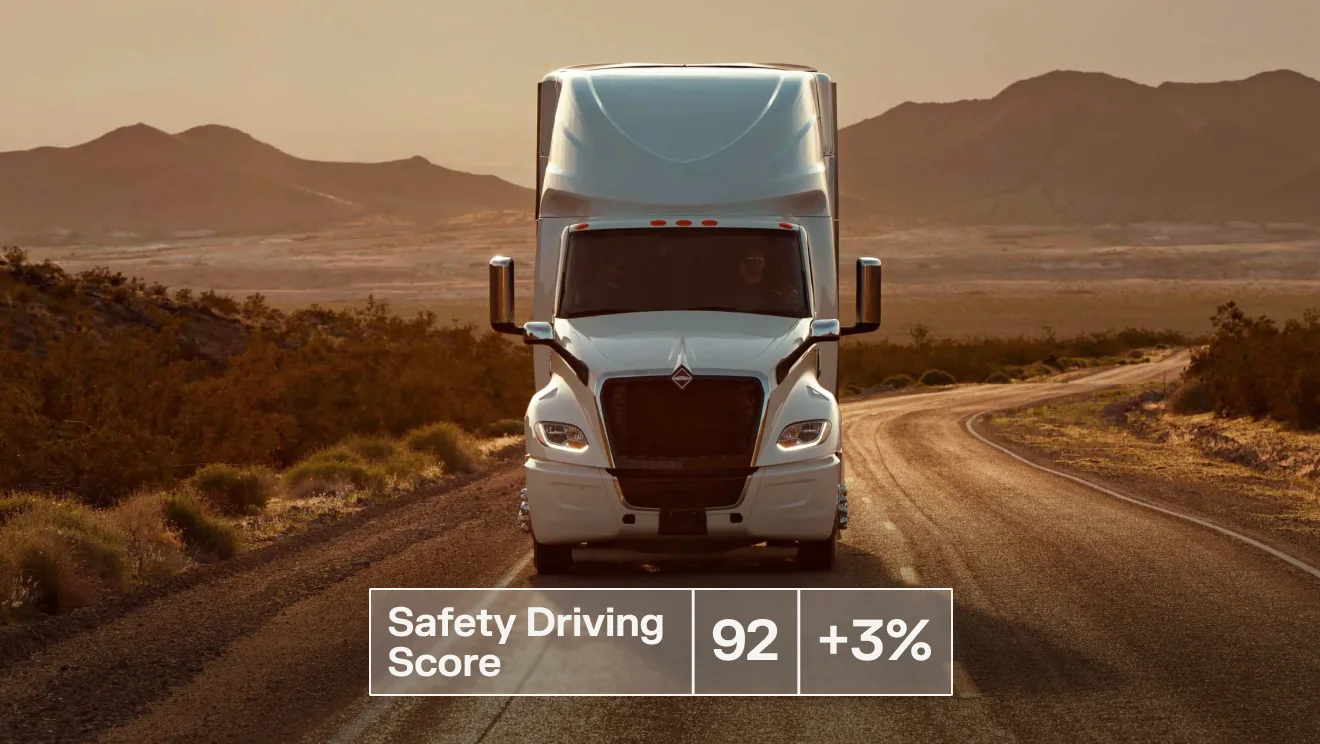 White semi-truck driving on a desert road, displaying a Safety Driving Score of 92, up 3%.