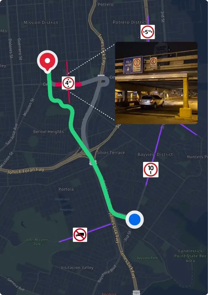 Límite de velocidad de 45 en la carretera, edificios comerciales, vista desde un vehículo con el espejo lateral visible.