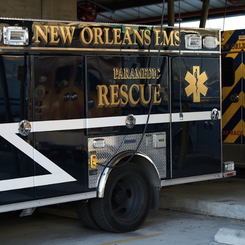 A black and gold New Orleans EMS Paramedic Rescue ambulance parked in a garage bay.