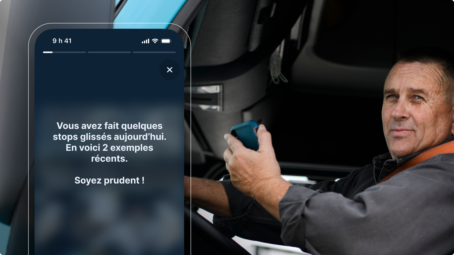 Un conducteur dans la cabine d’un camion consulte une alerte pour stops glissés avec rappel de sécurité sur son smartphone.
