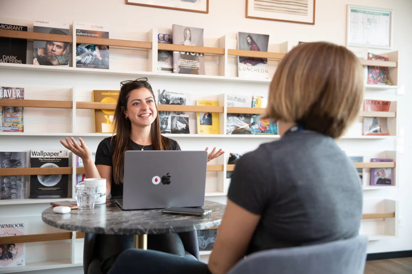 Samsara employees sitting in Samsara Office in Munich smiling at each other.
