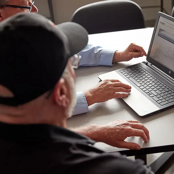 two people looking at a laptop
