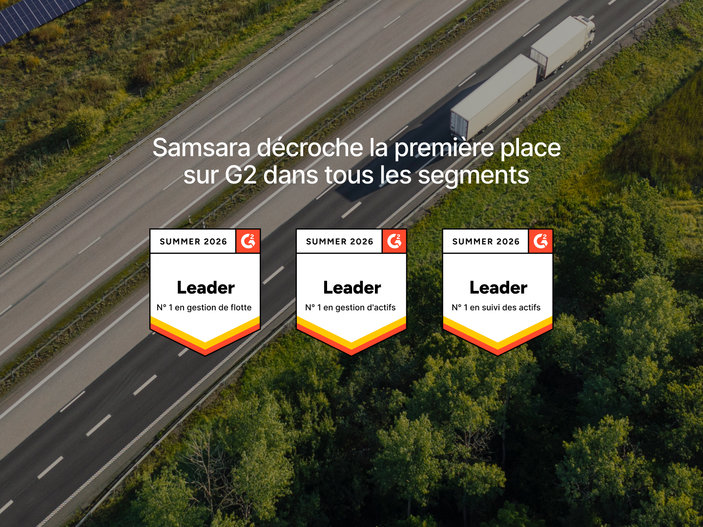 Vue aérienne d'une autoroute avec un camion blanc. Samsara affiche trois badges G2 Leader Été 2026 pour la gestion de flotte et d'actifs.