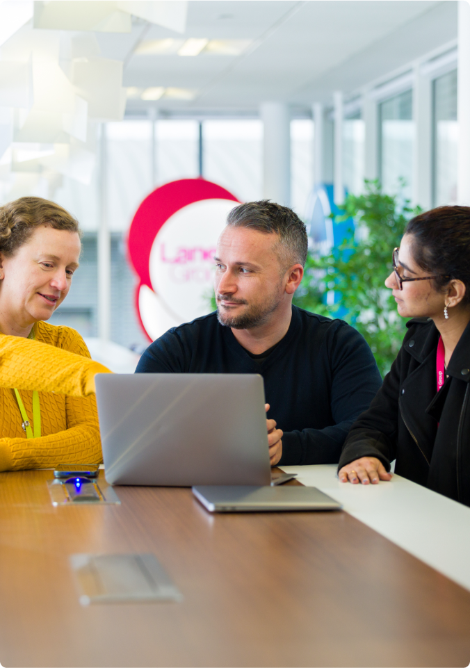 people working sitting around laptop