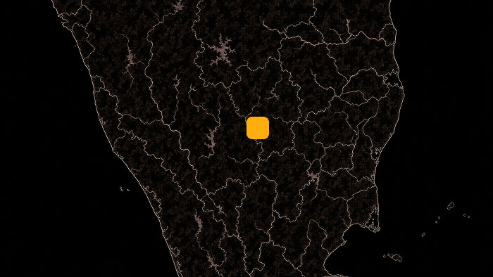 Dark map of a region with an orange square marker highlighting a central location.