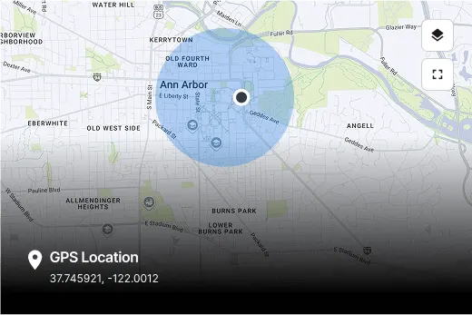 Map of Ann Arbor showing a blue circular radius around the downtown area with GPS coordinates displayed at bottom.