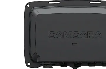 Close-up of a black Samsara device with a rectangular shape, mounting points, and the Samsara logo embossed on top.