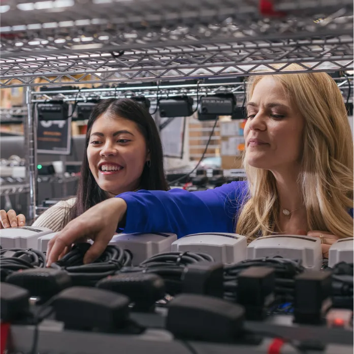 Samsara employees smiling and looking at Samsara products.