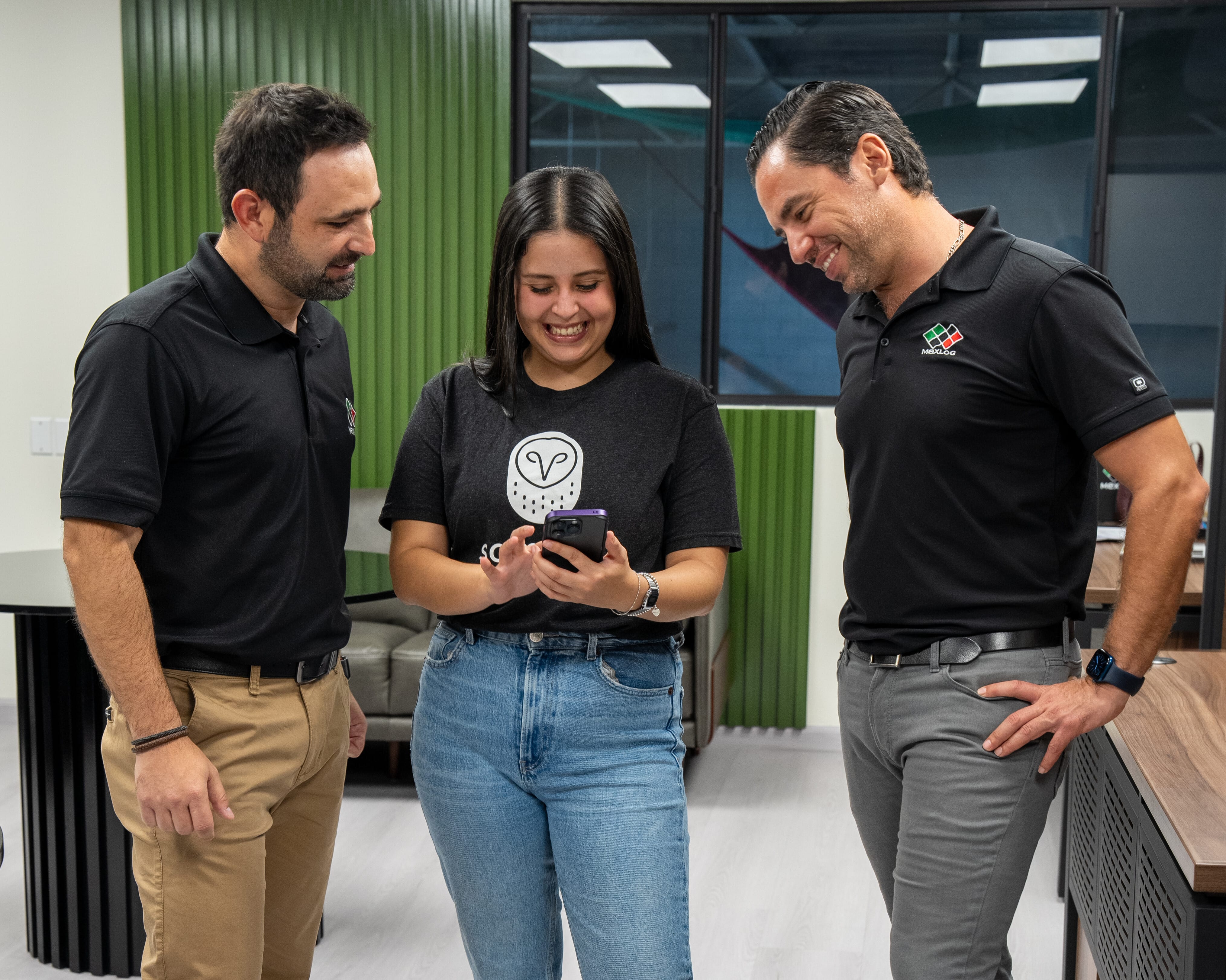 3 trabajadores que observan un teléfono