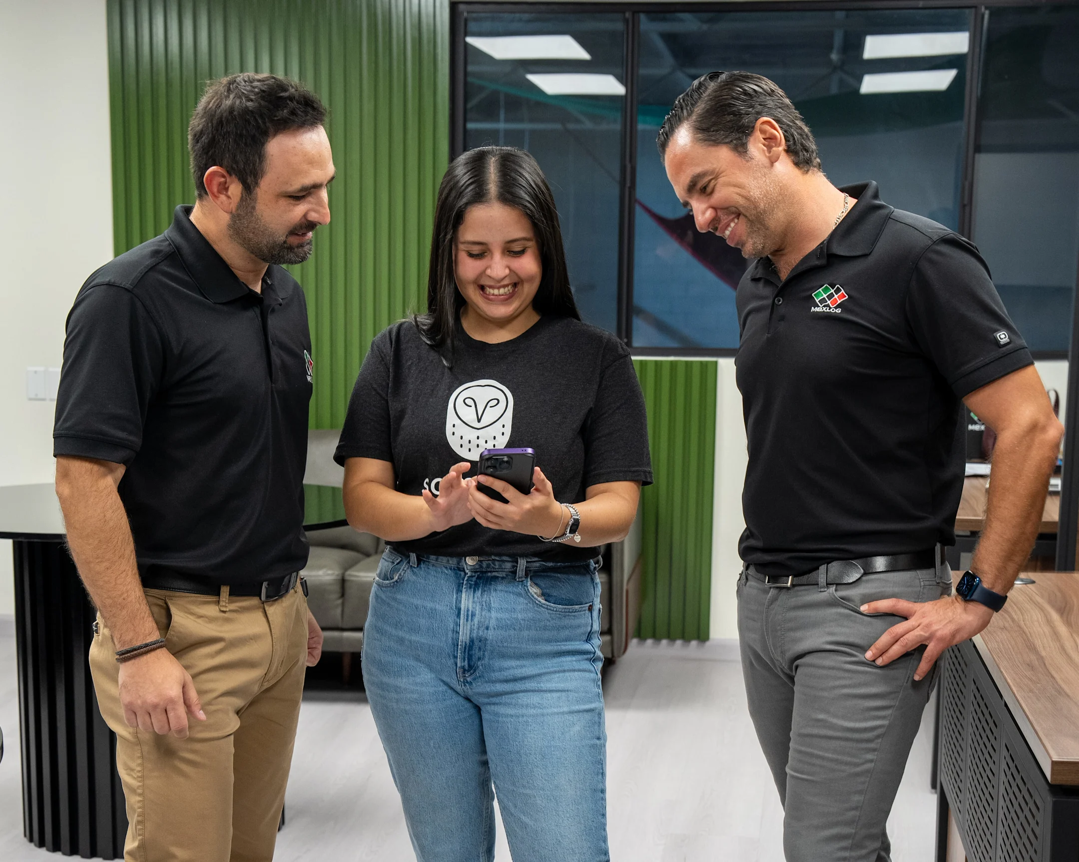 3 trabajadores que observan un teléfono