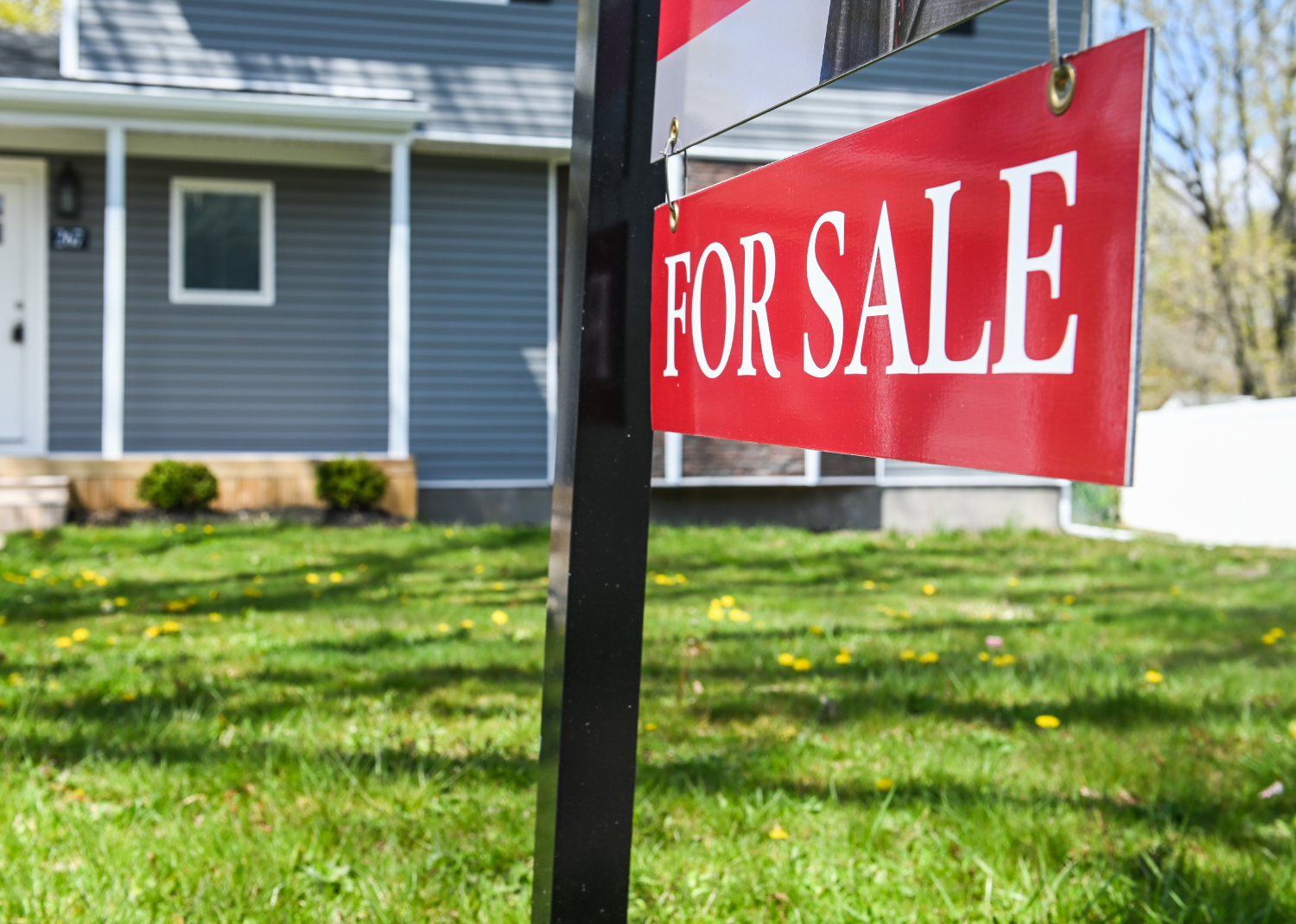 Photograph of a “For Sale” sign in front of a house - Newsday LLC // Getty Images