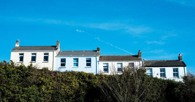 Four Homes Tiered in a Row Against a Blue Sky