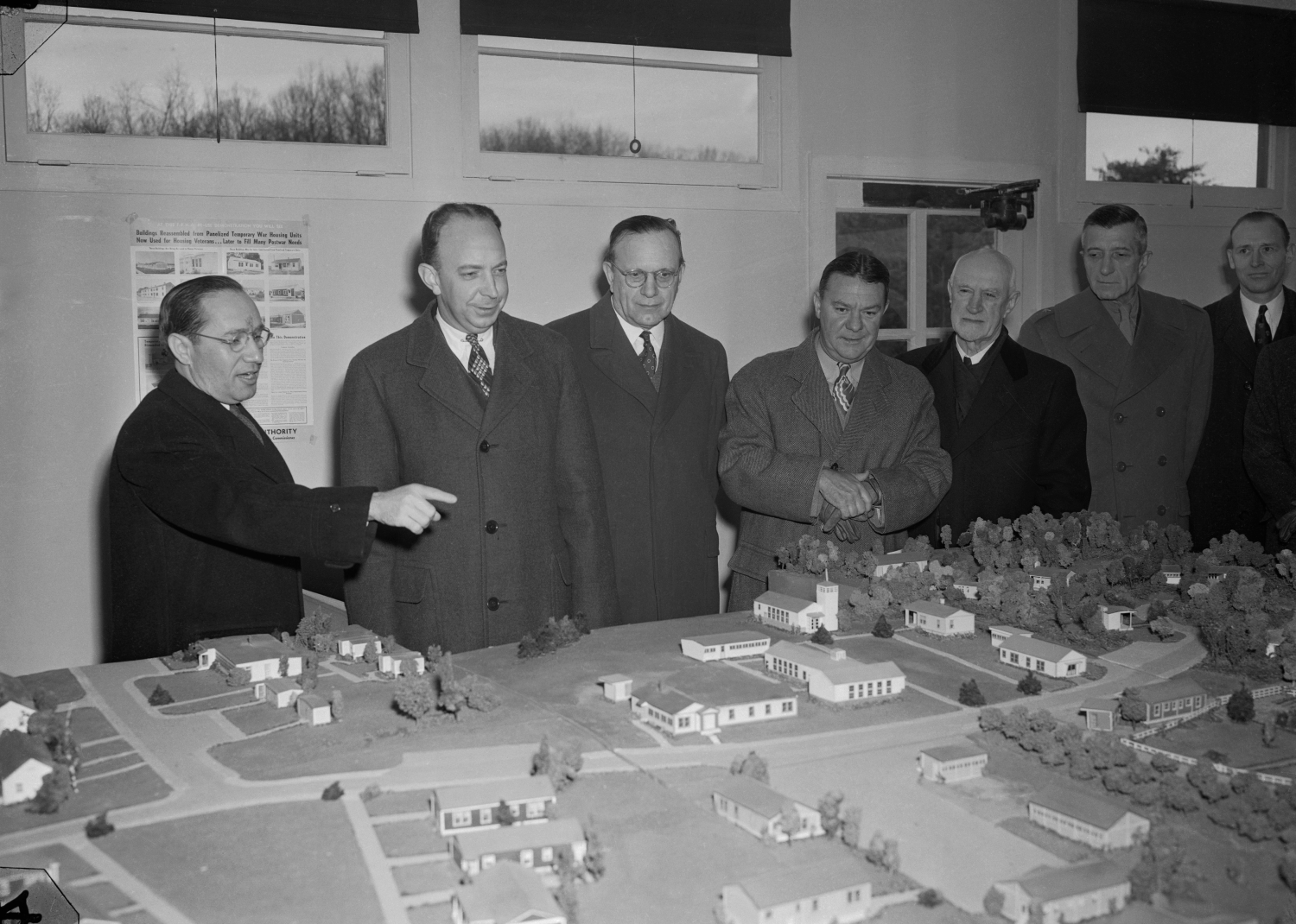 Photo of housing officials examining a scale model of a planned neighborhood - Bettmann // Getty Images
