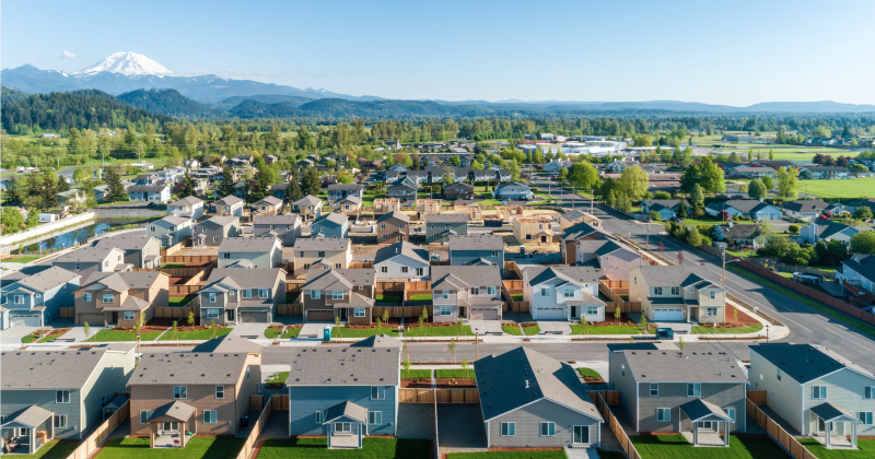 Drone Image of a Suburban Neighborhood with Mountain Landscape in Background