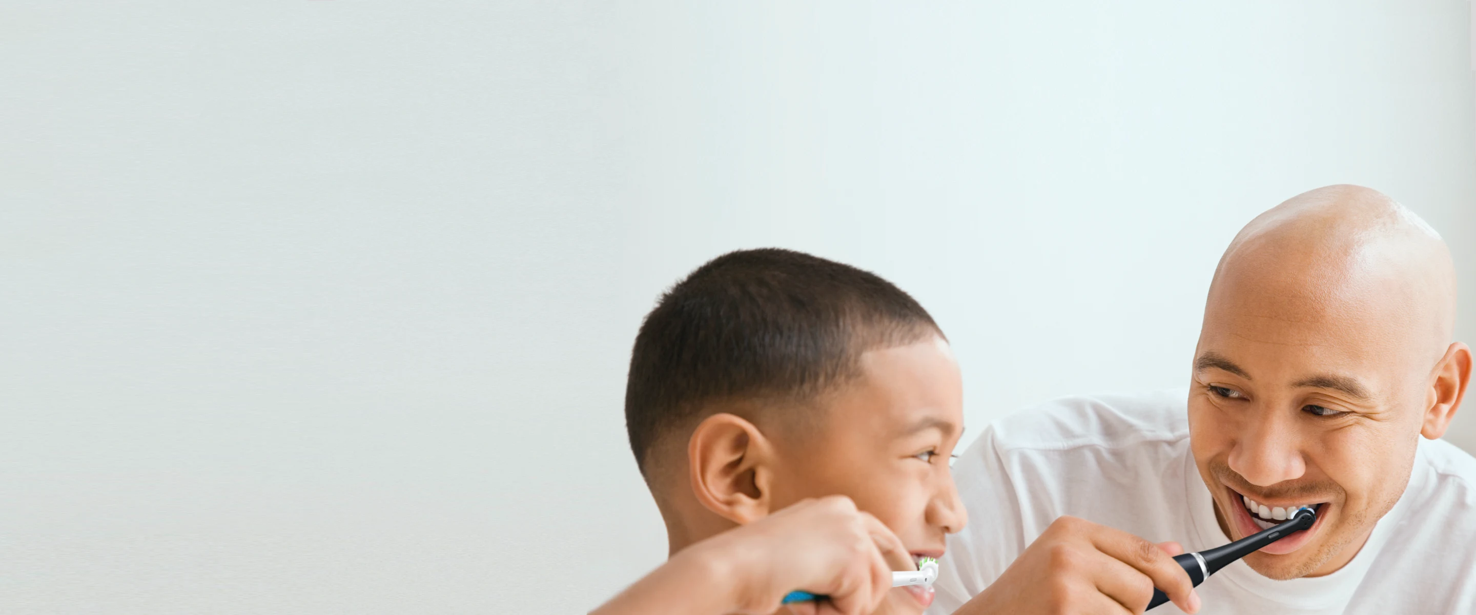 Mies ja lapsi harjaavat hampaitaan Oral-B-hammasharjoilla undefined