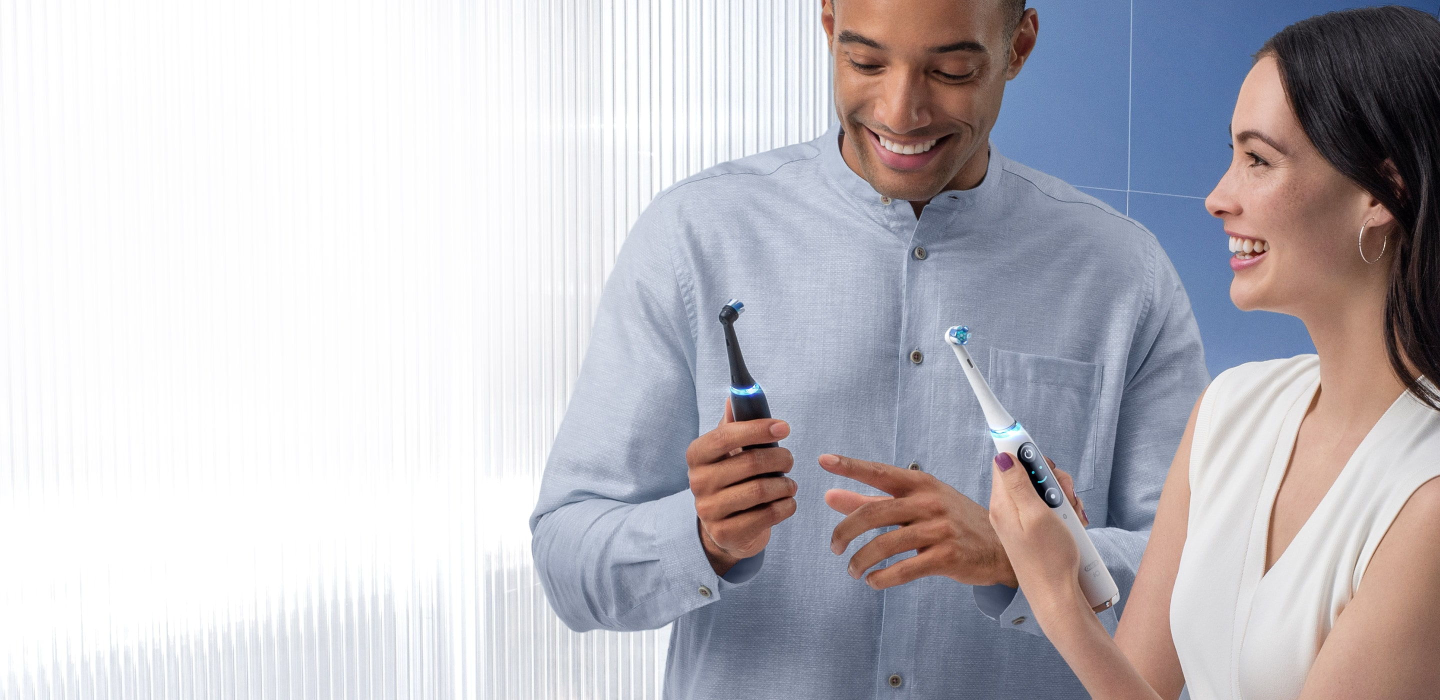 Mies ja nainen harjaavat hampaita tavallisilla Oral-B-hammasharjoilla undefined