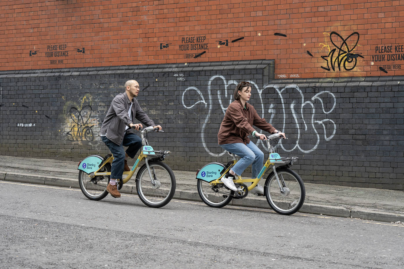 Two people riding starling bank bikes